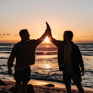 two men clapping each other on shore