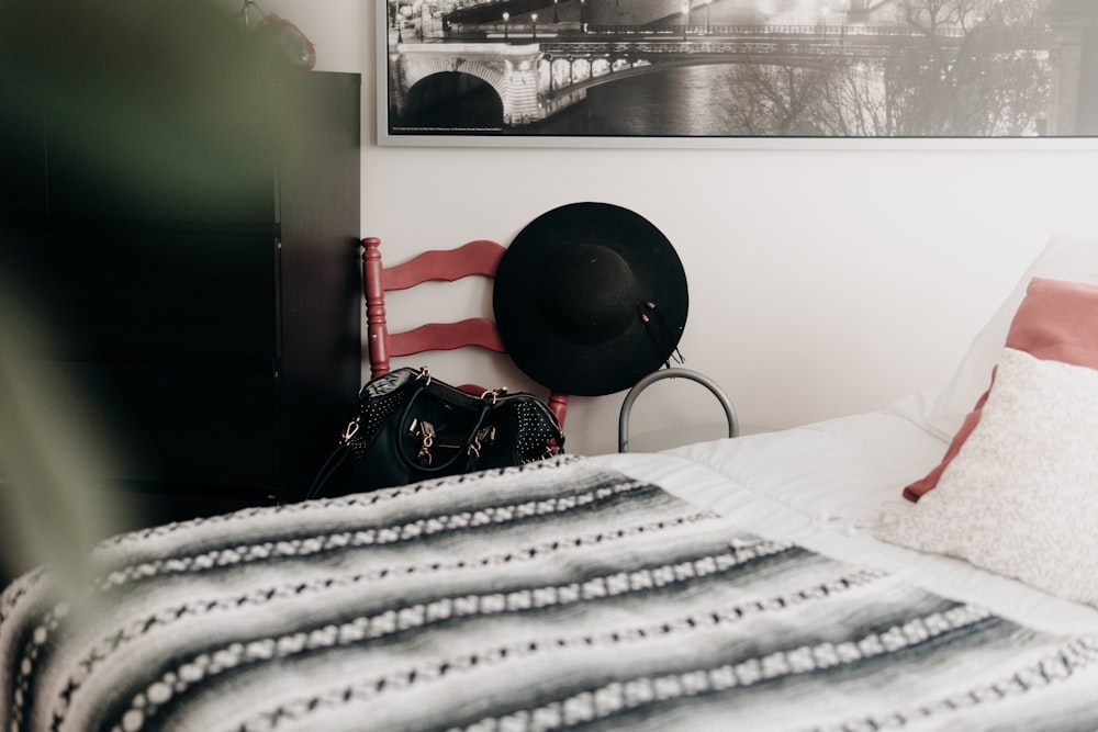 black hat near white and gray comforter