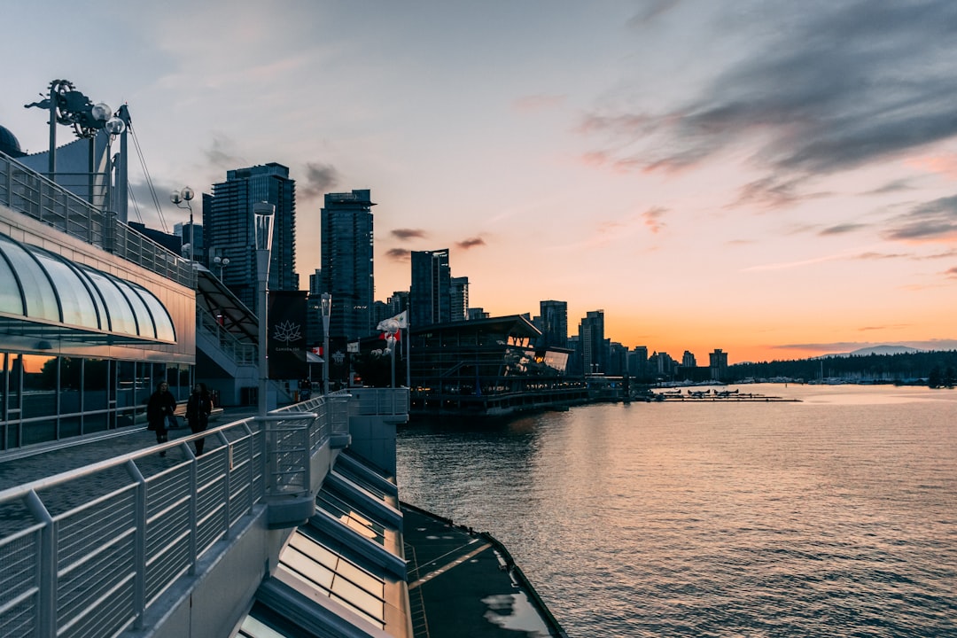 two men walking on street near to body of water, Canada Place Sunset