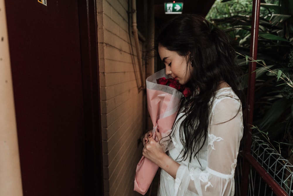 woman holding rose bouquet facing door