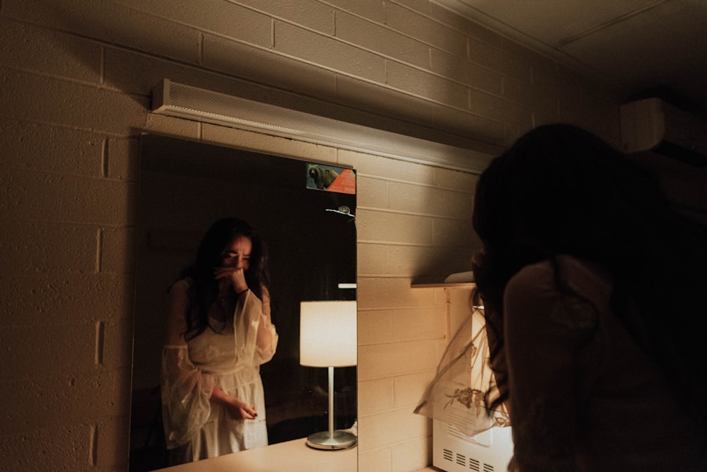 woman crying in front of mirror