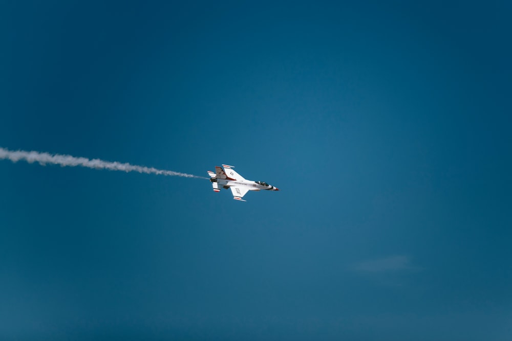 white jetplane with white smoke trails