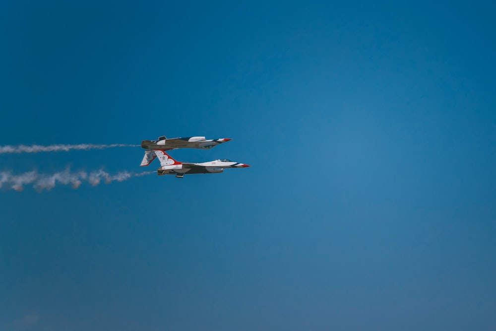 low-angle photography of two white-and-blue aircraft