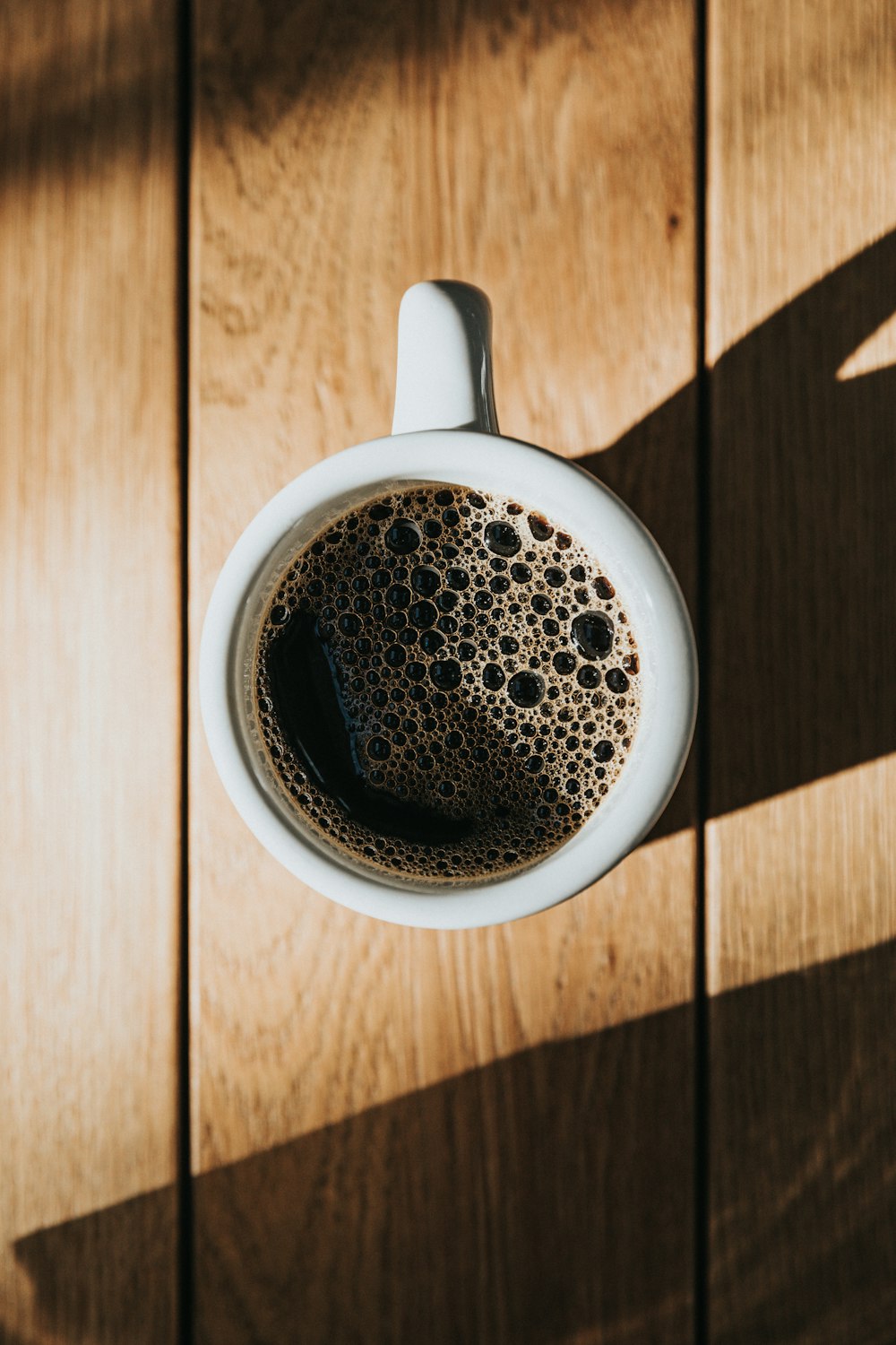 white ceramic mug on brown wooden surface