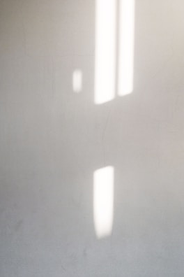 Abstract geometric shapes casting gentle shadows on a wall.