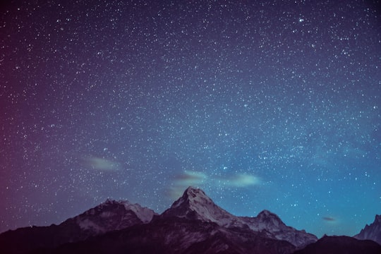 icy mountains under starry night in Poon Hill Nepal