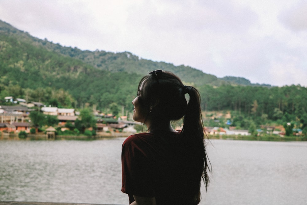 woman facing body of water at daytime