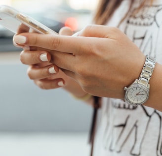 woman holding iPhone during daytime