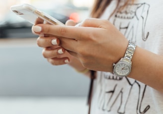 woman holding iPhone during daytime