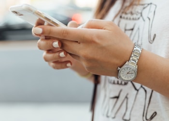 woman holding iPhone during daytime