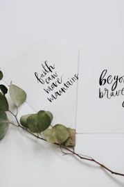 green rose leaves and two cards flat lay photography
