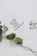 Two white cards with inspirational quotes written in black cursive text are overlapping. One card reads 'faith can move mountains' and the other says 'be your brave'. A dried branch with green leaves is placed beneath the cards, adding a natural touch.