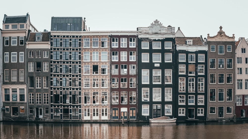 concrete buildings beside body of water