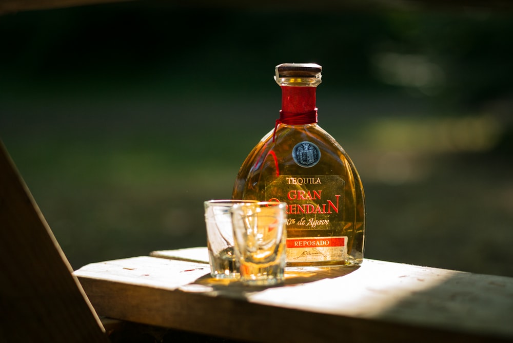 two rock glasses beside bottle