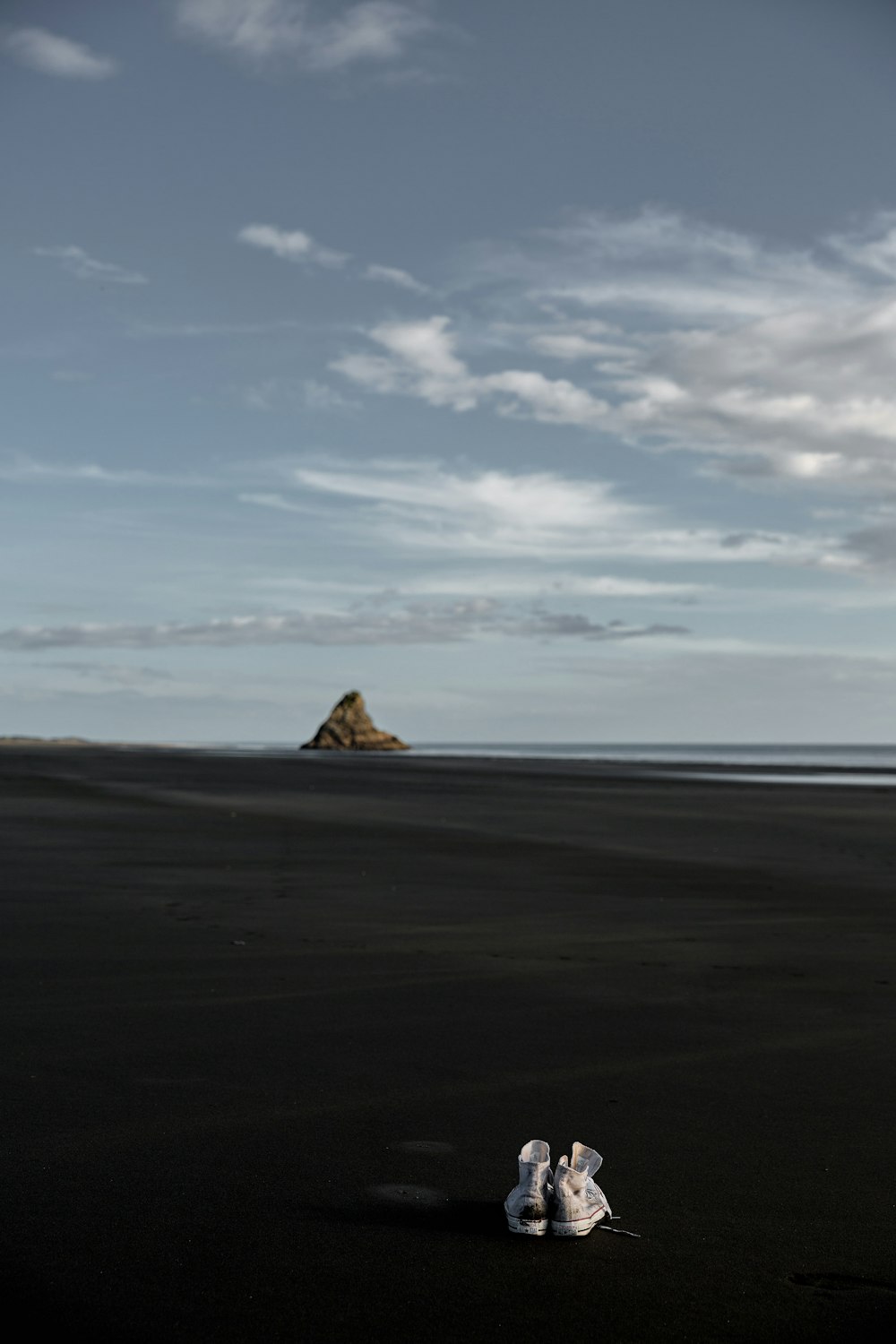 pair of sneakers on black sand