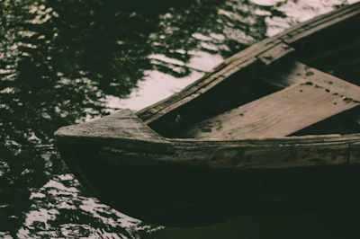 Close-up of a traditional wooden boat resting by the riverbank, weathered by time.