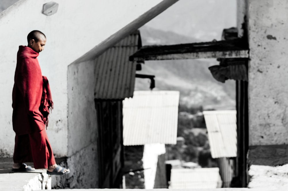 selective color photography of man standing on concrete surface