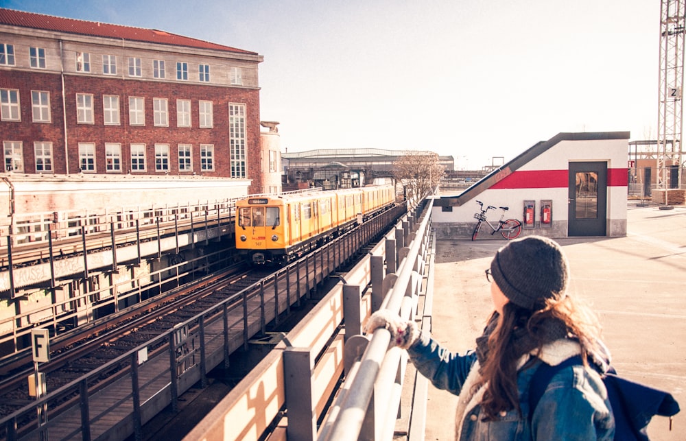 man wearing gray knit hat holding gray steel handrail