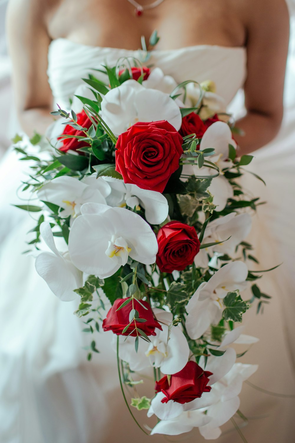 Bouquet de roses rouges et d’orchidées blanches