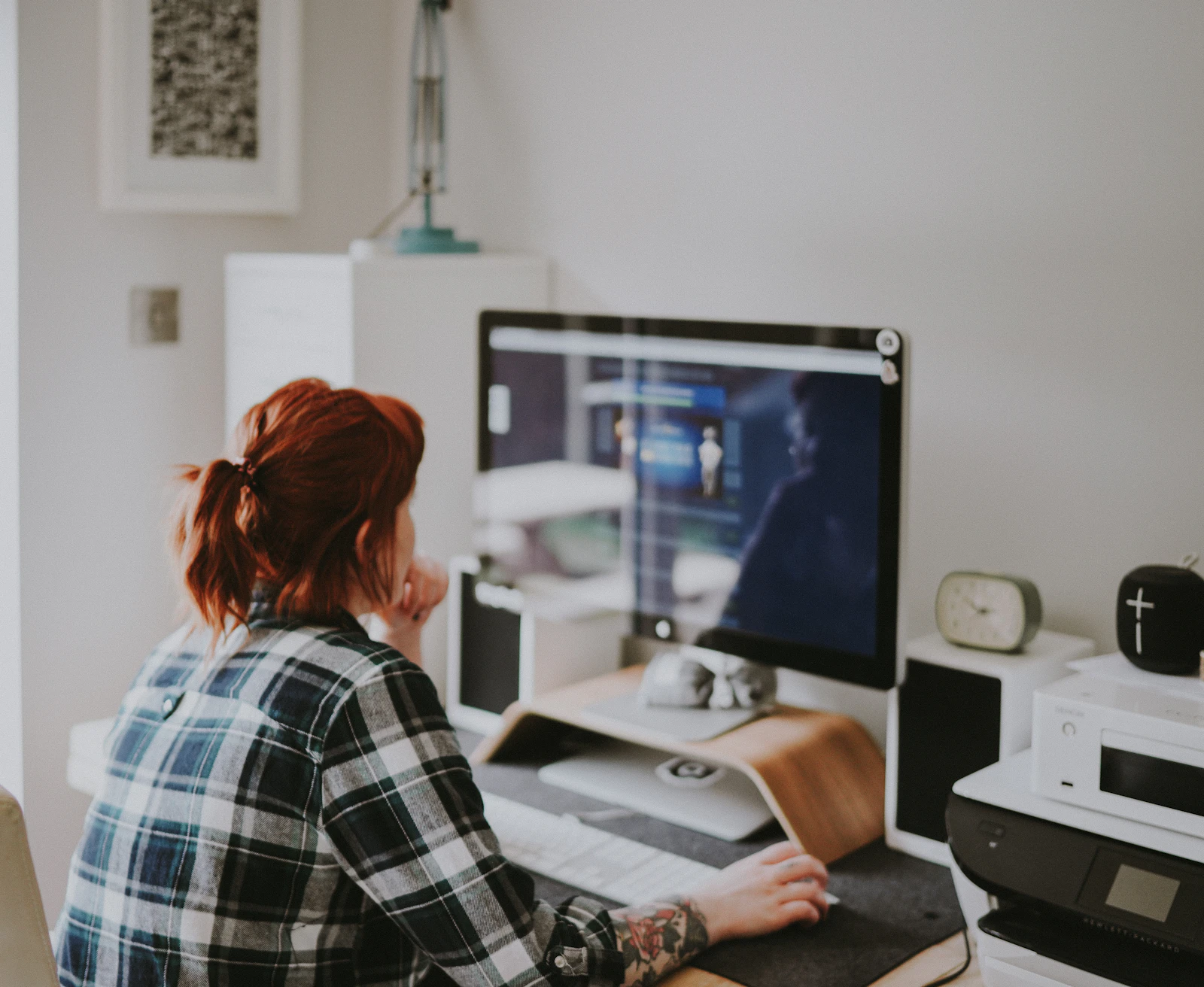 Woman browsing on a laptop at a home desk