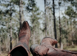 selective focus photography of person wearing cowboy boots