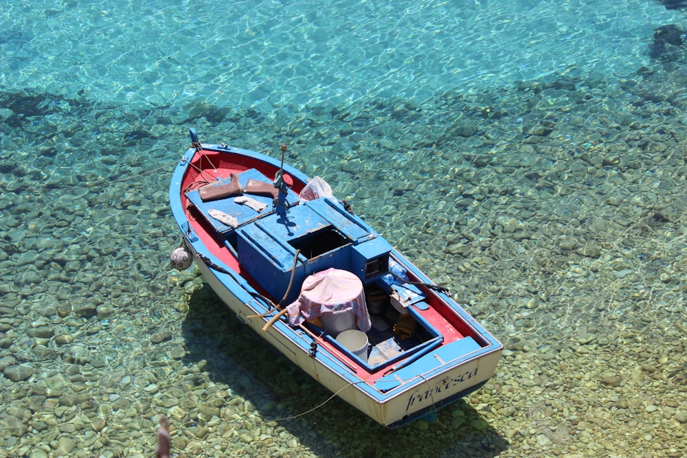 blue and red boat toy on body of water