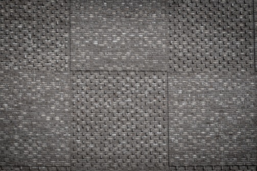 Detailed stone and brick textures on a medieval castle wall in Minecraft.