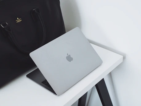 A sleek laptop on a clean desk with blue and black tech accessories, symbolizing professional IT support.