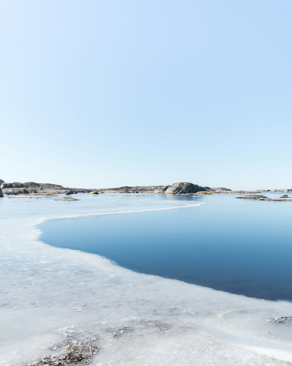 body of water cover with snow near mountain