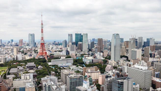 A detailed coloring page preview showing Tokyo Tower with the penguins exploring.