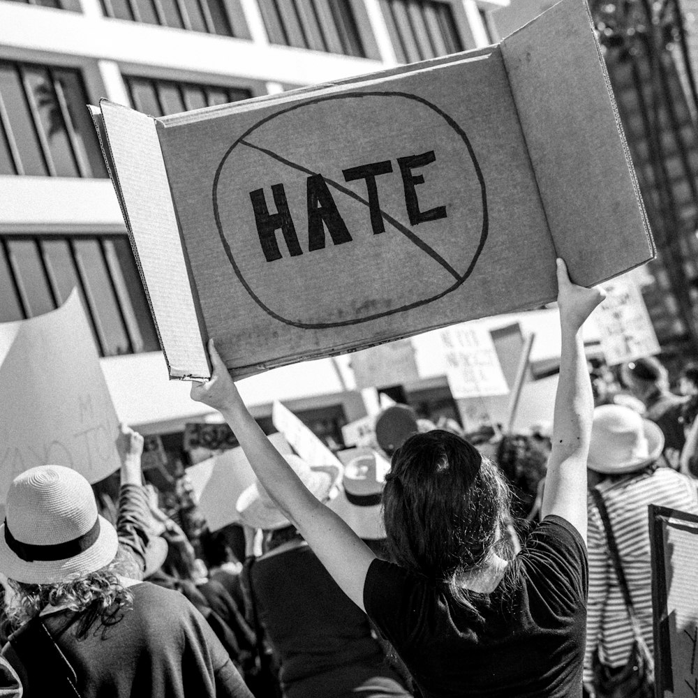 woman holding Hate signage