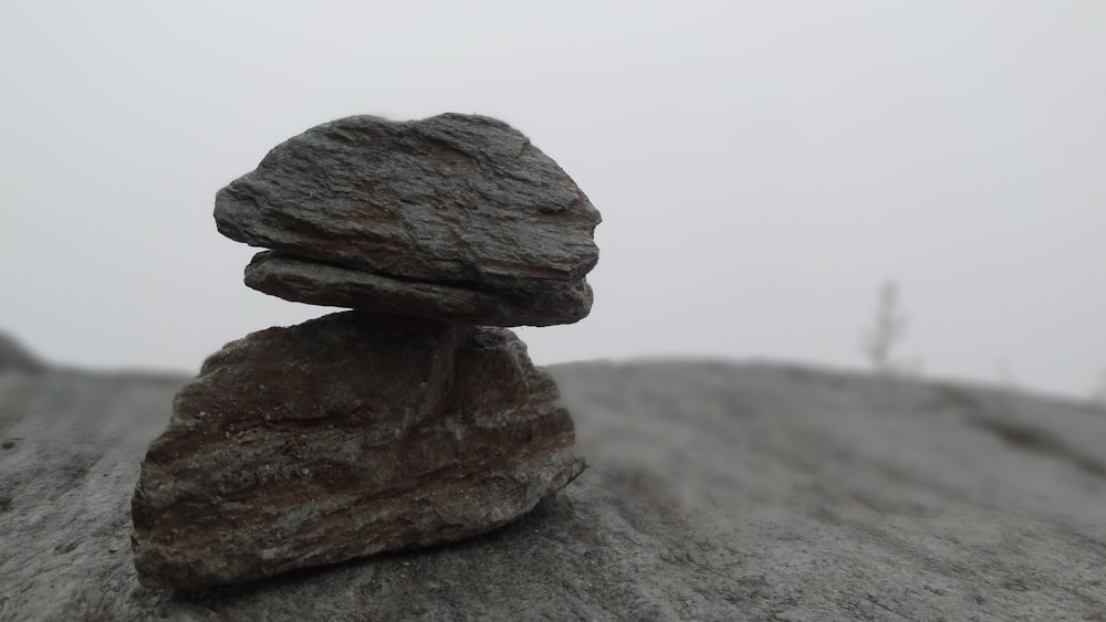 closeup photo of two gray stones on sand