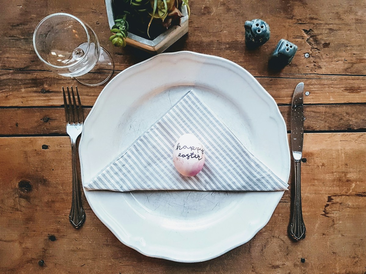 A classroom table set with Easter-themed crafts, colorful eggs, and a school Easter party sign-up sheet.
