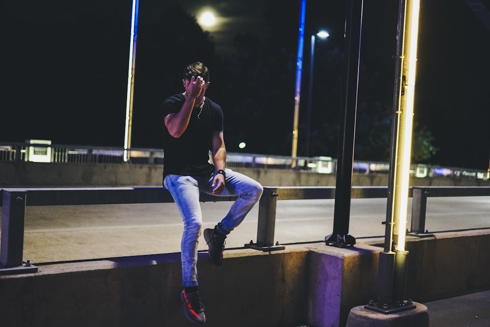 man sitting on gray metal gray metal grille during night time photo