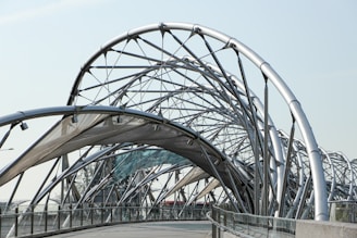 low angle photography of pathway under gray metal spiral frame