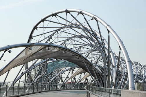 low angle photography of pathway under gray metal spiral frame