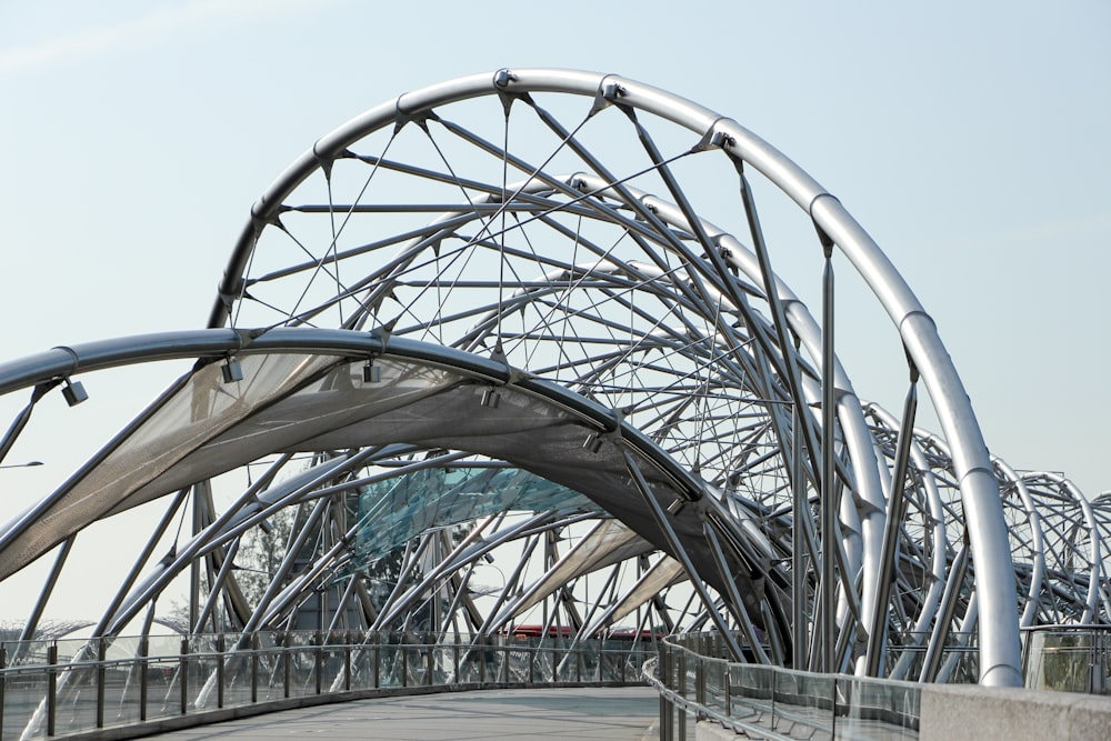 low angle photography of pathway under gray metal spiral frame