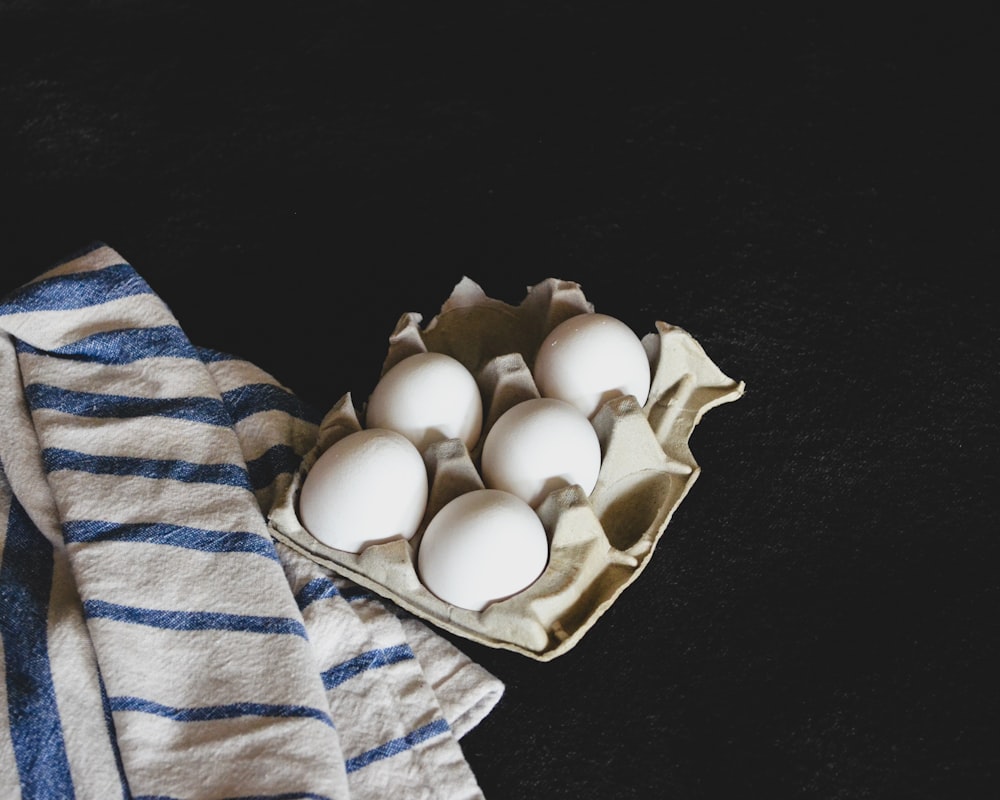 five eggs on brown carton tray