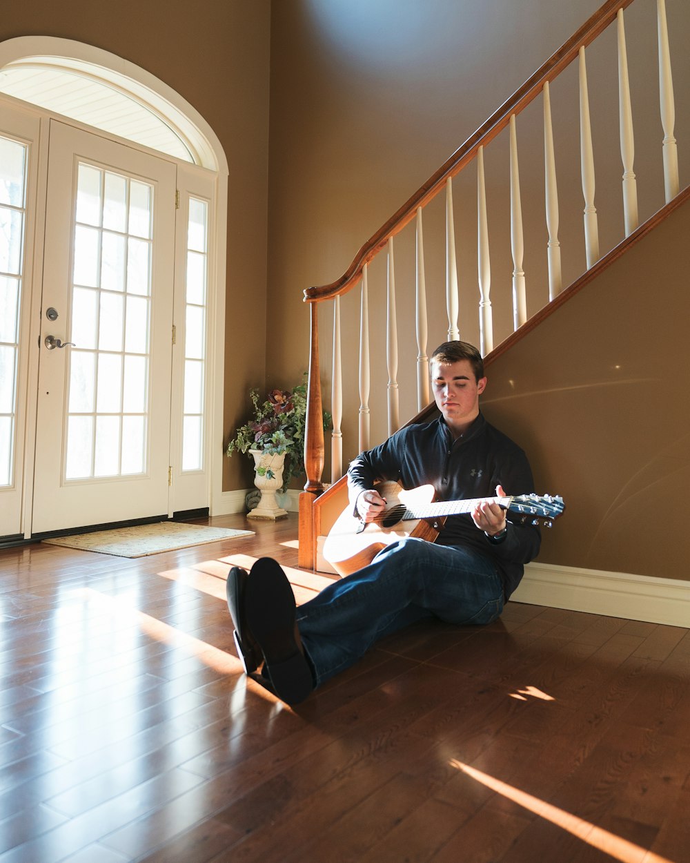 man playing guitar leaning on stairs