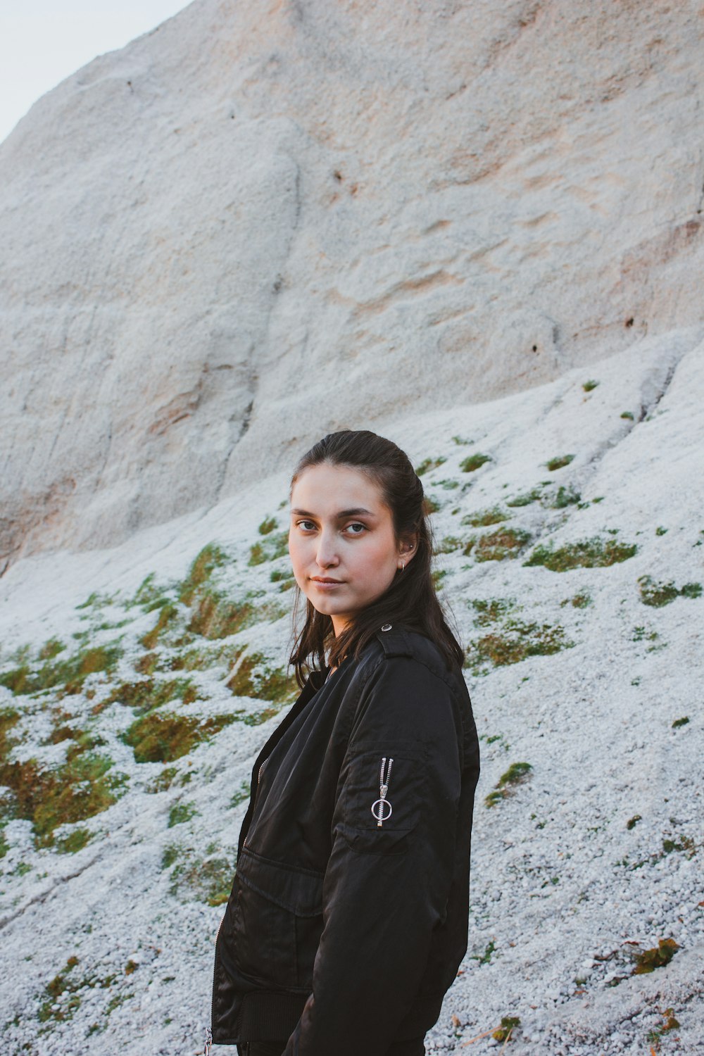 woman standing beside rock formation