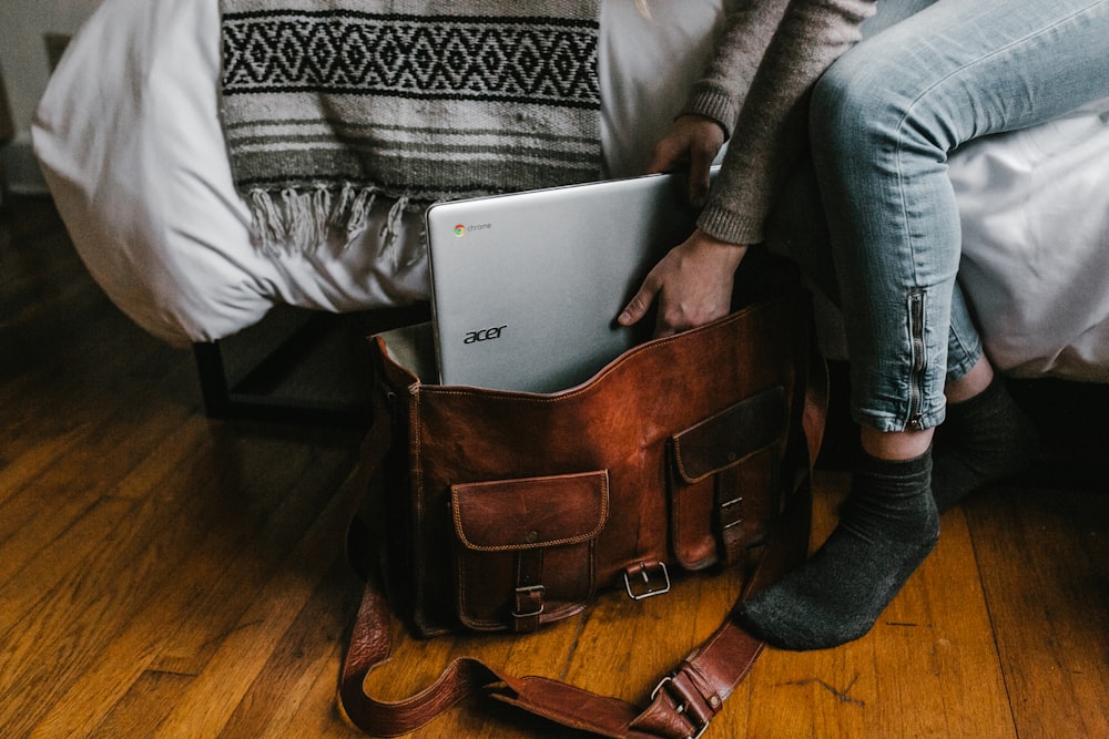 personne tenant un ordinateur portable Chromebook Acer argenté