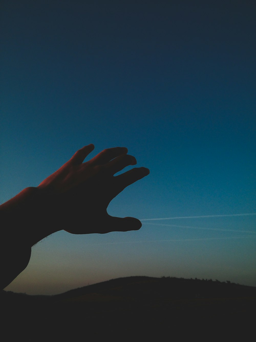 person raising hand on sky