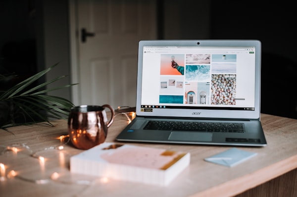 A laptop and a cup of coffee sitting on a desk