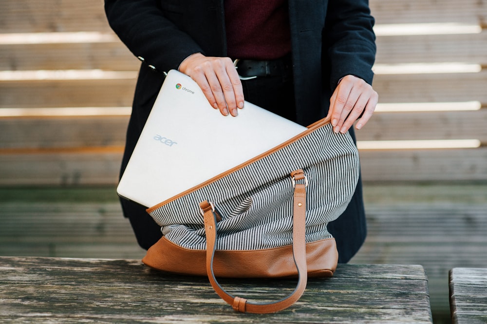 mulher colocando um Chromebook Acer em um saco