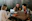 three people sitting in front of table laughing together
