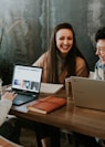 three people sitting in front of table laughing together