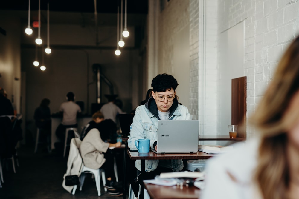 Frau mit weißer Jacke mit Laptop-Computer