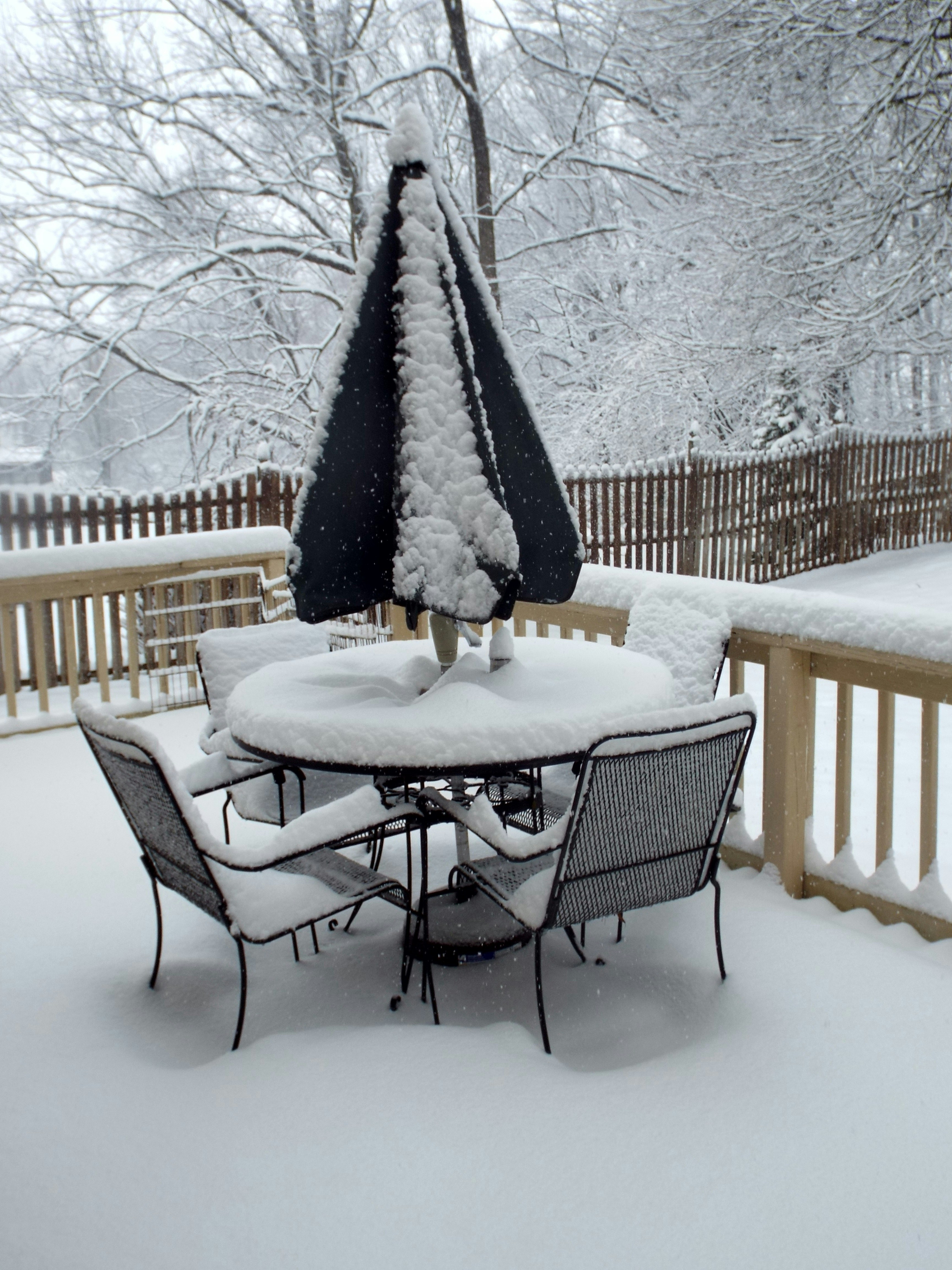 Large empty patio slab with no cover, outdoor grill exposed to rain and snow