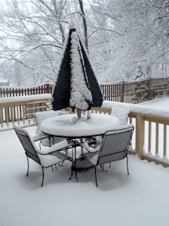 Weatherproof metal patio table cover protecting a table during a gentle rain.