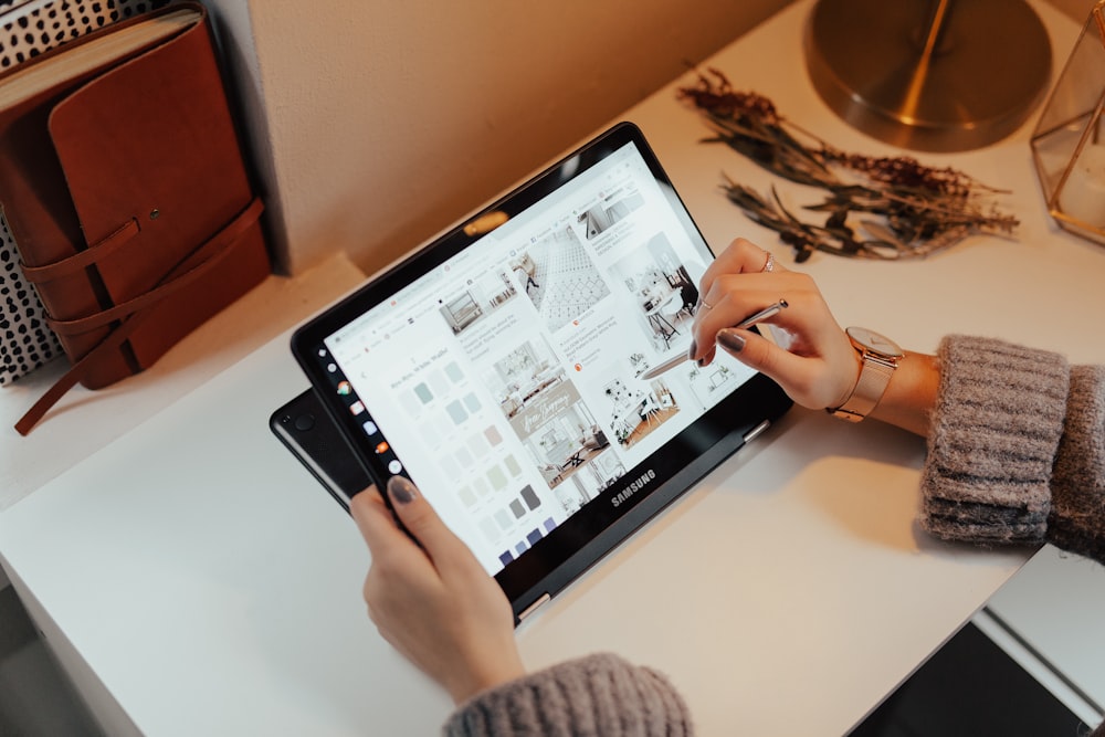 person holding black tablet computer